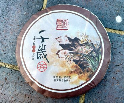 An unopened ripe puerh tea cake outside on the driveway
