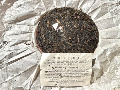 The fact of an open wrapper aged raw puerh tea cake with label