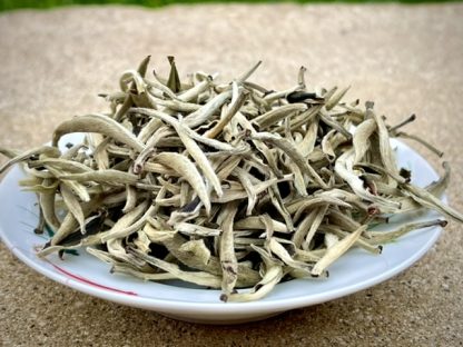 Yunnan silver bud white tea in a bowl on stone outside?