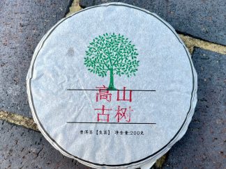 An unopened Gushu raw puerh tea cake outside on the driveway