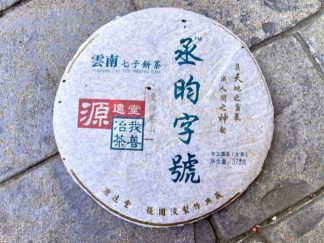 An unopened raw puerh tea cake on the driveway outside