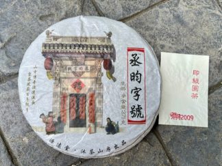 A raw puerh tea cake on the driveway outside