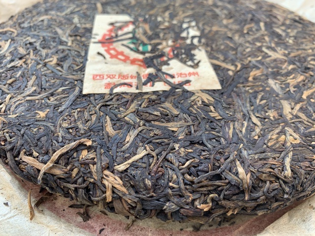 Close up of the front of a CNNP raw puerh tea cake