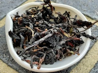 Close-up of Gushu Chinese black tea on a plate on a brick outside