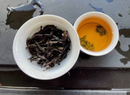 Gaiwan with Yancha oolong and tea cup on a Chinese table